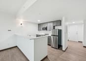 Thumbnail 28 of 45 - A modern kitchen with a white countertop and stainless steel appliances.