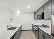Thumbnail 16 of 45 - A modern kitchen with stainless steel appliances and wooden flooring.