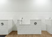Thumbnail 42 of 45 - A white tiled bathroom with two sinks and a bathtub.