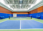 Thumbnail 7 of 45 - A tennis court with a net and two benches.