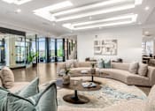 Thumbnail 41 of 45 - A modern living room with a large sectional sofa and a coffee table.