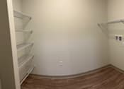 Thumbnail 19 of 21 - Empty walk-in closet with shelves and a wooden floor.at Arbours at Moores Mill, Huntsville Alabama