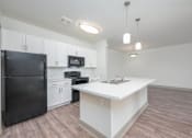 Thumbnail 19 of 20 - A kitchen with black appliances and white cabinets.
