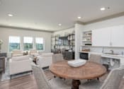 Thumbnail 12 of 20 - A modern kitchen with a dining table and chairs.