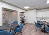 Thumbnail 18 of 20 - A dining room with a round table and blue chairs.