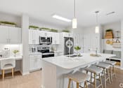 Thumbnail 32 of 41 - A modern kitchen with white cabinets and a large island.