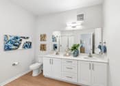Thumbnail 36 of 41 - A white bathroom with a white toilet and a white sink.