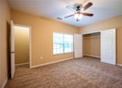 Thumbnail 16 of 26 - A room with a ceiling fan and carpeted floor.