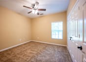 Thumbnail 11 of 26 - A room with a ceiling fan and a window with blinds.