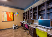 Thumbnail 9 of 26 - A room with a desk, computer, and a painting on the wall.