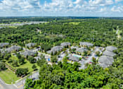 Thumbnail 2 of 26 - A bird's eye view of a residential area with houses surrounded by greenery.