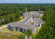 Thumbnail 2 of 8 - An aerial view of a large building surrounded by trees. at Arbours at Kingsland, Kingsland, 31548