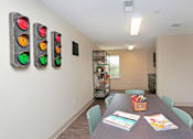 Thumbnail 24 of 32 - A room with a table, chairs, and a wall with traffic lights on it at Arbours at Tumblin Creek ~ Active 55+ Adult Community, Gainesville 32608