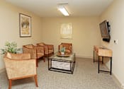 Thumbnail 25 of 32 - A living room with a couch, chairs, a coffee table, and a television at Arbours at Tumblin Creek ~ Active 55+ Adult Community, Gainesville, Florida