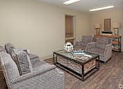 Thumbnail 26 of 32 - A living room with grey couches and a glass coffee table at Arbours at Tumblin Creek ~ Active 55+ Adult Community, Gainesville