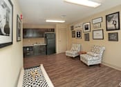 Thumbnail 27 of 32 - A living room with two chairs and pictures on the wall at Arbours at Tumblin Creek ~ Active 55+ Adult Community, Florida