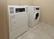 Thumbnail 29 of 32 - Two front loading washing machines in a laundry room at Arbours at Tumblin Creek ~ Active 55+ Adult Community, Gainesville, FL 32608