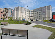 Thumbnail 14 of 32 - A park area with benches and a building in the background at Arbours at Tumblin Creek ~ Active 55+ Adult Community, 32608