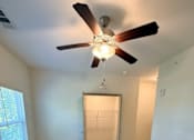Thumbnail 9 of 17 - A room with a ceiling fan and carpeted floor.