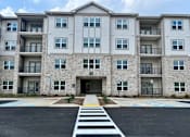 Thumbnail 3 of 21 - A large apartment building with a crosswalk in front.at Arbours at Moores Mill, Huntsville, AL 35811