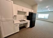 Thumbnail 9 of 21 - A kitchen with white cabinets and a black refrigerator.at Arbours at Moores Mill, Huntsville