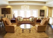 Thumbnail 2 of 18 - A living room with a brown sofa, two matching chairs and a coffee table at Arbours at Ensley Apartments, Pensacola, Florida