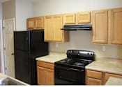 Thumbnail 9 of 18 - A kitchen with wooden cabinets and black appliances at Arbours at Ensley Apartments, Pensacola, Florida