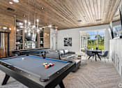 Thumbnail 16 of 41 - A pool table is in the middle of a room with a wooden ceiling.