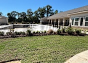 Thumbnail 4 of 5 - A house with a black fence and a green lawn at Arbours at Lake Charles, Lake Charles, Louisiana