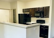 Thumbnail 5 of 17 - A kitchen with black appliances at Arbours at Covington Apartments, Georgia, 30014