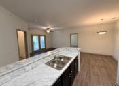 Thumbnail 15 of 17 - A kitchen with a marble countertop and a sink.