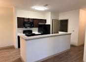 Thumbnail 16 of 17 - A kitchen with a white counter and black appliances.