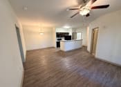 Thumbnail 12 of 17 - A room with a ceiling fan and wooden flooring.