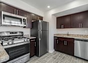 Thumbnail 10 of 27 - A kitchen with a stove, refrigerator, and cabinets. at Chatham Hill, New Jersey, 07928