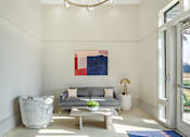 Thumbnail 4 of 13 - A modern living room with a grey couch, a grey armchair, a wooden coffee table, and a large abstract painting on the wall at The Addison,Louisiana 70836