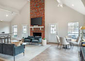 Thumbnail 4 of 20 - A living room with a grey couch and a fireplace.