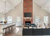 Thumbnail 5 of 20 - A living room with a fireplace and a couch.