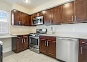 Thumbnail 16 of 27 - A kitchen with brown cabinets and stainless steel appliances. at Chatham Hill, New Jersey, 07928