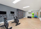 Thumbnail 17 of 51 - a gym with exercise machines and a rock climbing wall at Copper and Quarry Village, Maryland, 21209