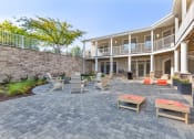 Thumbnail 4 of 51 - a patio with tables and chairs in front of a house at Copper and Quarry Village, Pikesville, MD