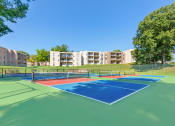 Thumbnail 49 of 51 - two tennis courts with apartments in the background at Copper and Quarry Village, Pikesville
