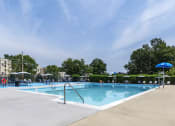 Thumbnail 1 of 51 - a swimming pool with umbrellas and buildings in the background at Copper and Quarry Village, Pikesville, MD, 21209
