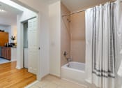 Thumbnail 32 of 46 - a bathroom with a shower and a tub and a door to a closet at Pier Village Apartments, Long Branch, NJ