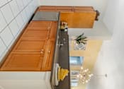 Thumbnail 19 of 46 - a kitchen with wooden cabinets and a counter top at Pier Village Apartments, Long Branch, NJ