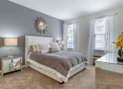 Thumbnail 26 of 46 - a bedroom with a bed and two windows at Pier Village Apartments, Long Branch, New Jersey