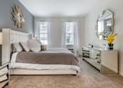 Thumbnail 25 of 46 - a bedroom with a large bed and a mirror on the wall at Pier Village Apartments, New Jersey