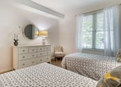 Thumbnail 29 of 46 - a bedroom with two beds and a dresser with a mirror at Pier Village Apartments, Long Branch, 07740