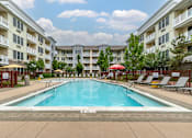Thumbnail 9 of 46 - a swimming pool with an apartment building in the background at Pier Village Apartments, New Jersey, 07740