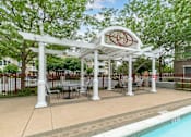 Thumbnail 14 of 46 - a gazebo with tables and chairs next to a swimming pool at Pier Village Apartments, New Jersey, 07740