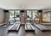 Thumbnail 18 of 46 - two treadmills and two bikes in a gym with windows at Pier Village Apartments, New Jersey, 07740